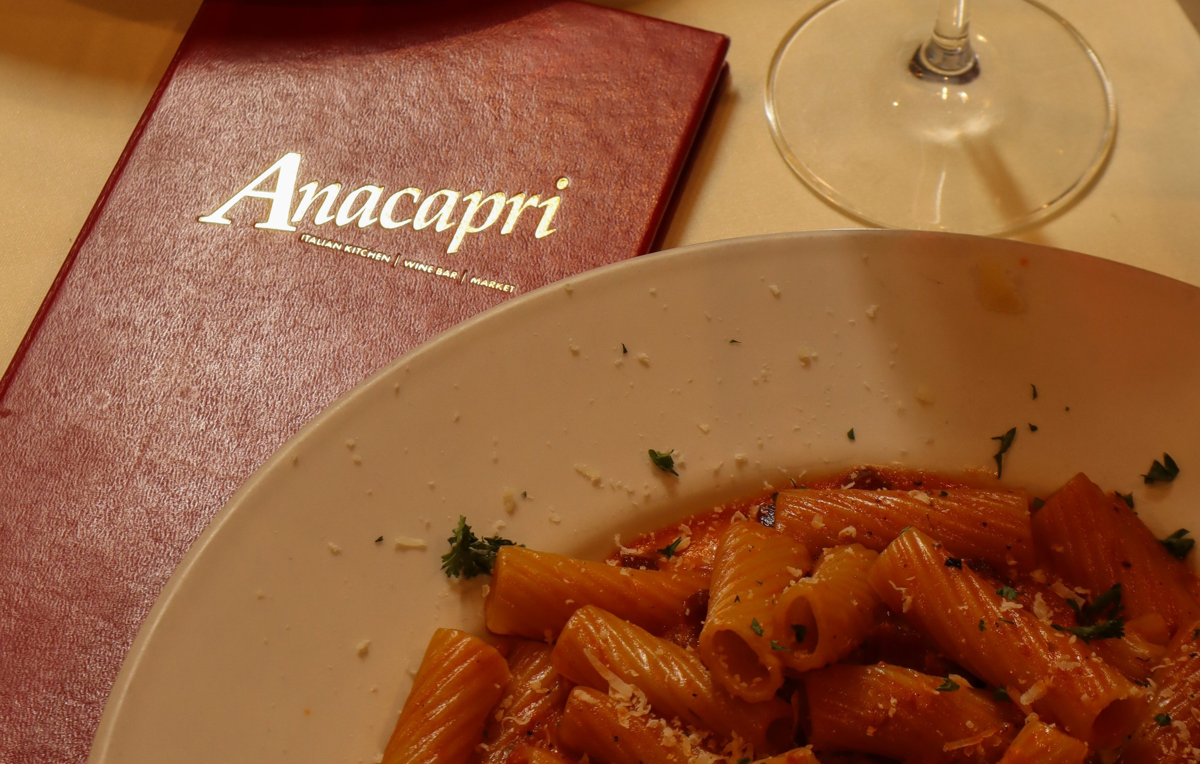 a plate of pink rigatoni pasta and the Anacapri Menu in Red on a tablescape