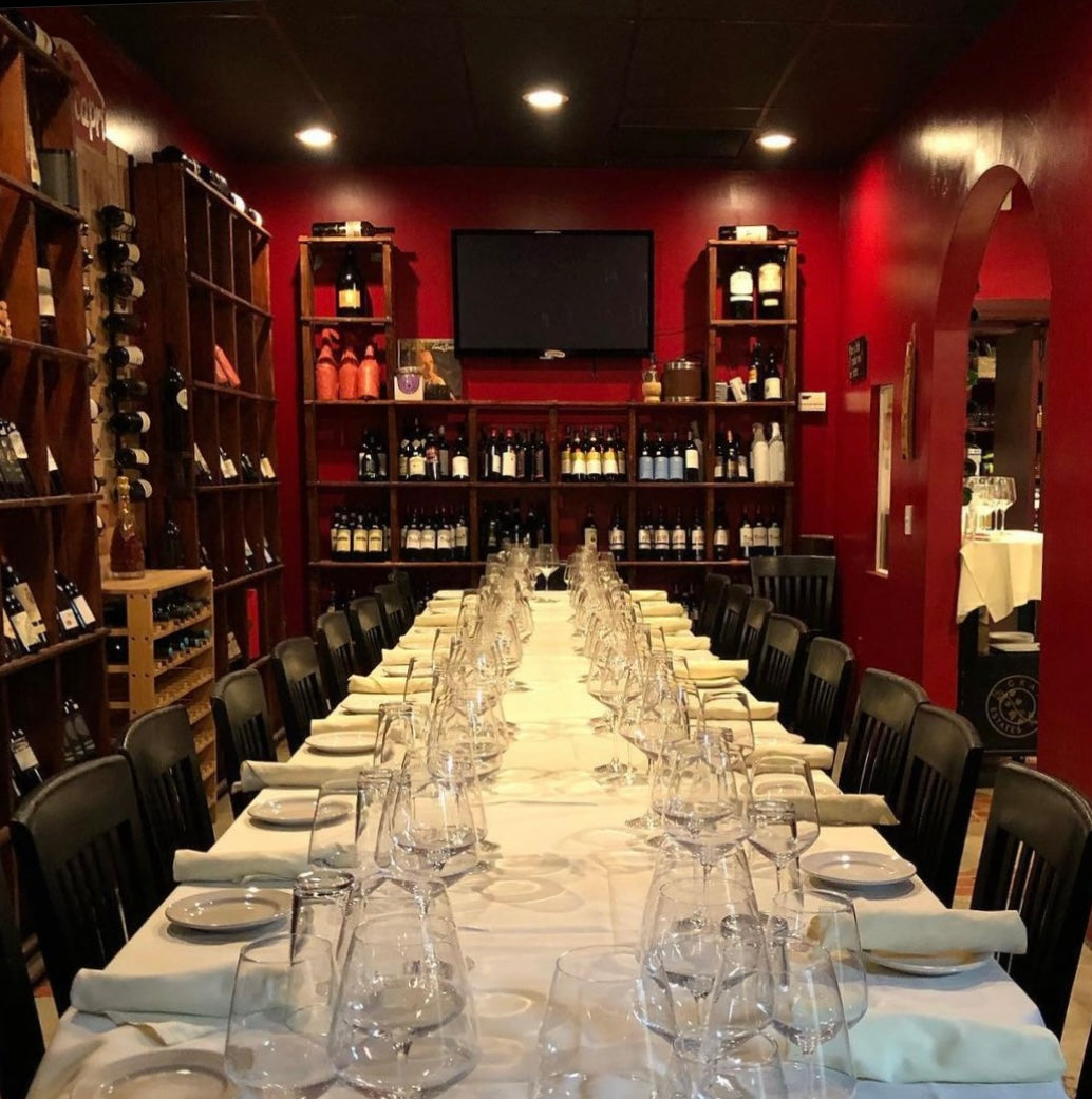 A photo of a large long table set up nicely for a private event in our private wine room.